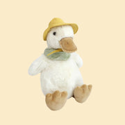 A white duck stuffed animal with a yellow hat and a green gingham scarf. 