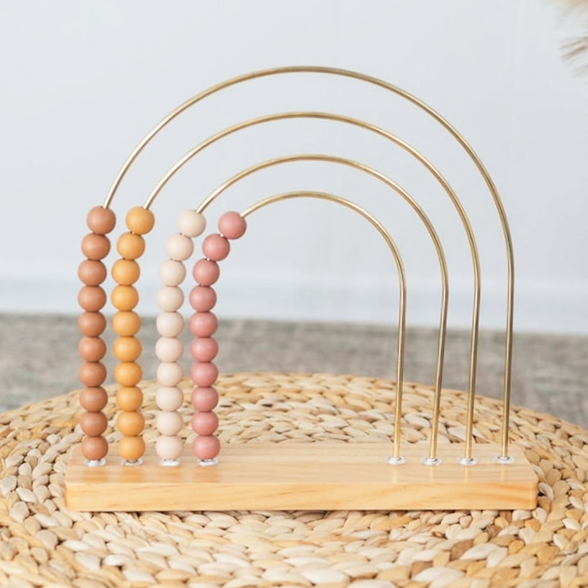 A wire and wood bead abacus toy in mauve tones. 