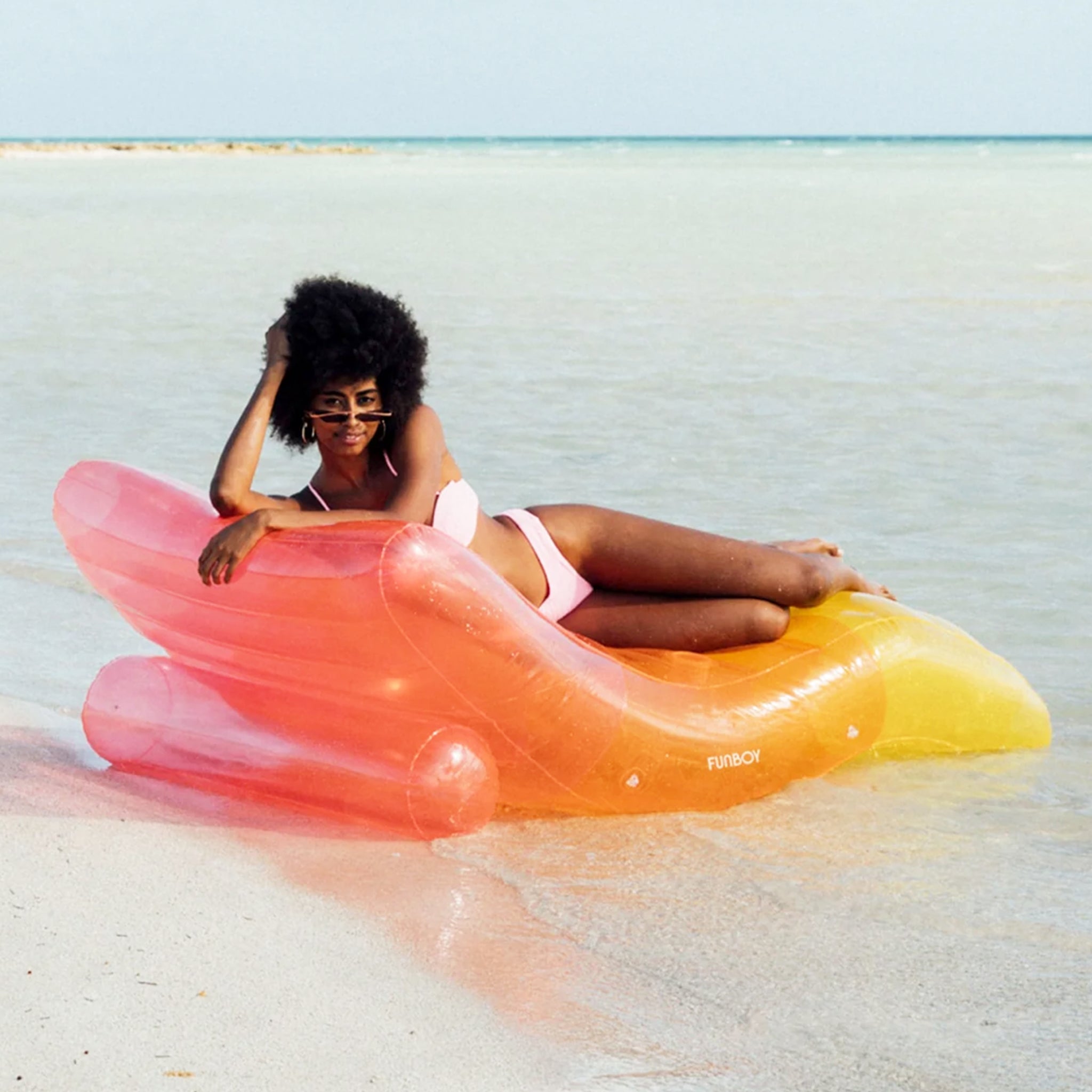A pink, orange and yellow ombre chaise lounge pool float.