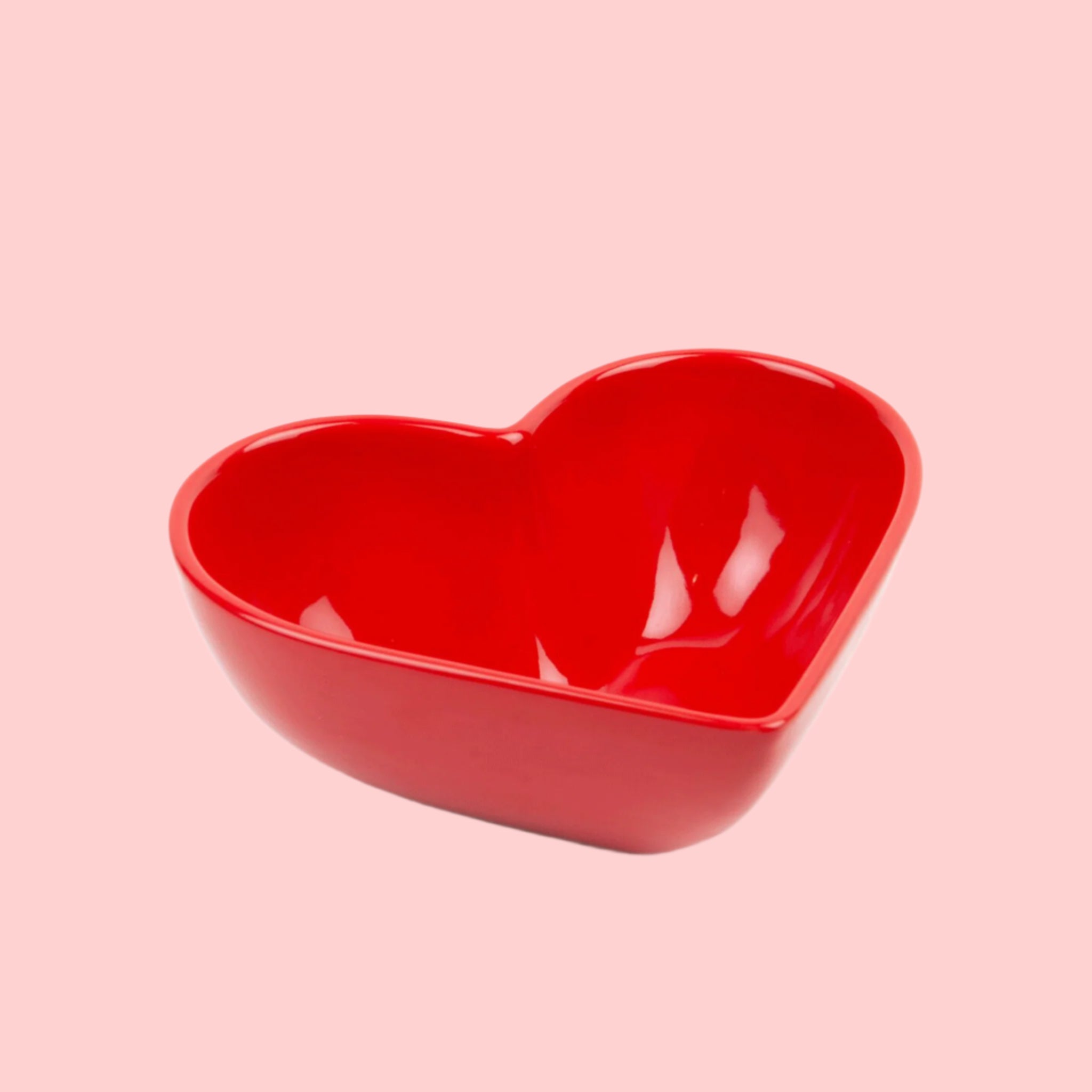 A red ceramic heart shaped bowl. 