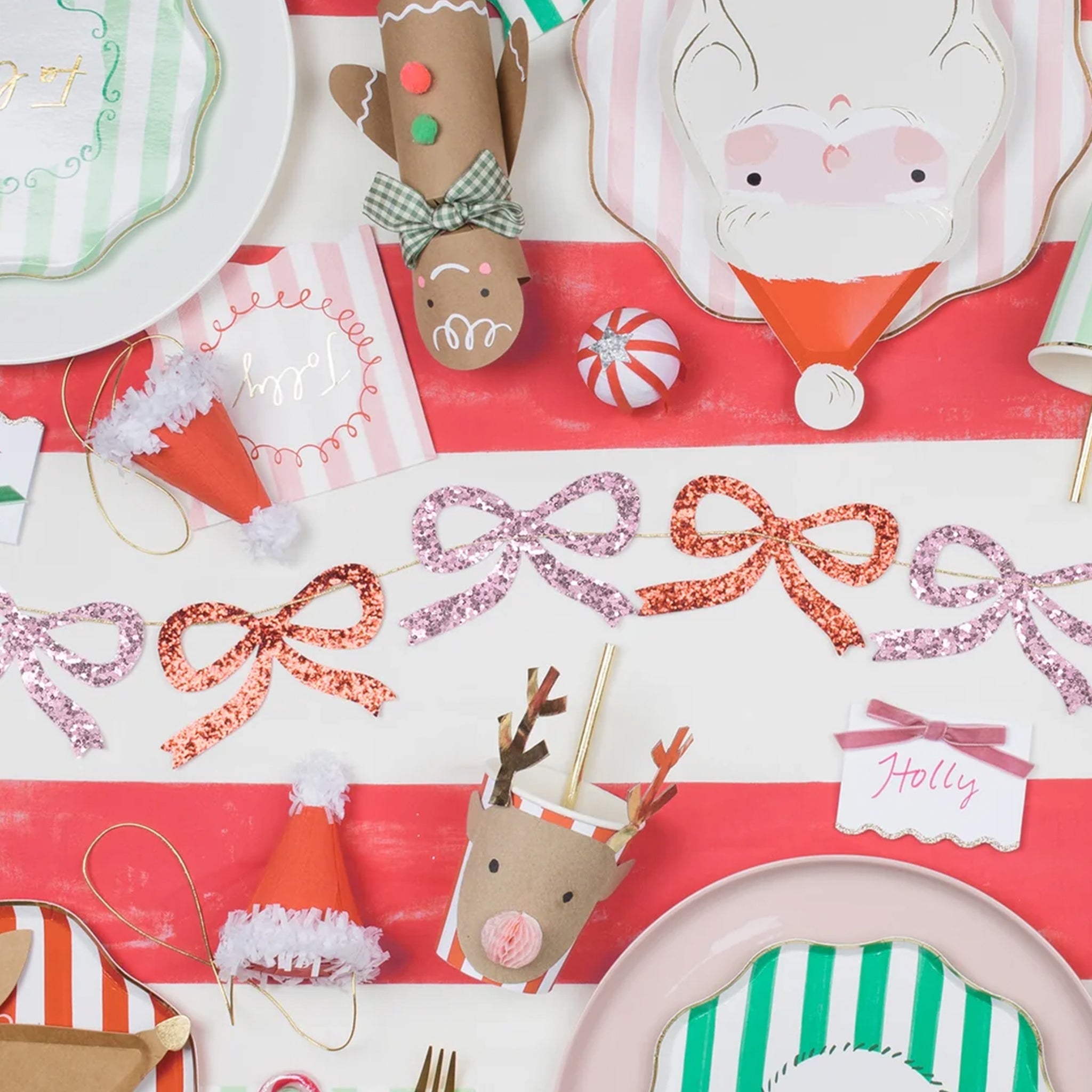 A pink and red glitter bow garland made out of paper cut outs. 