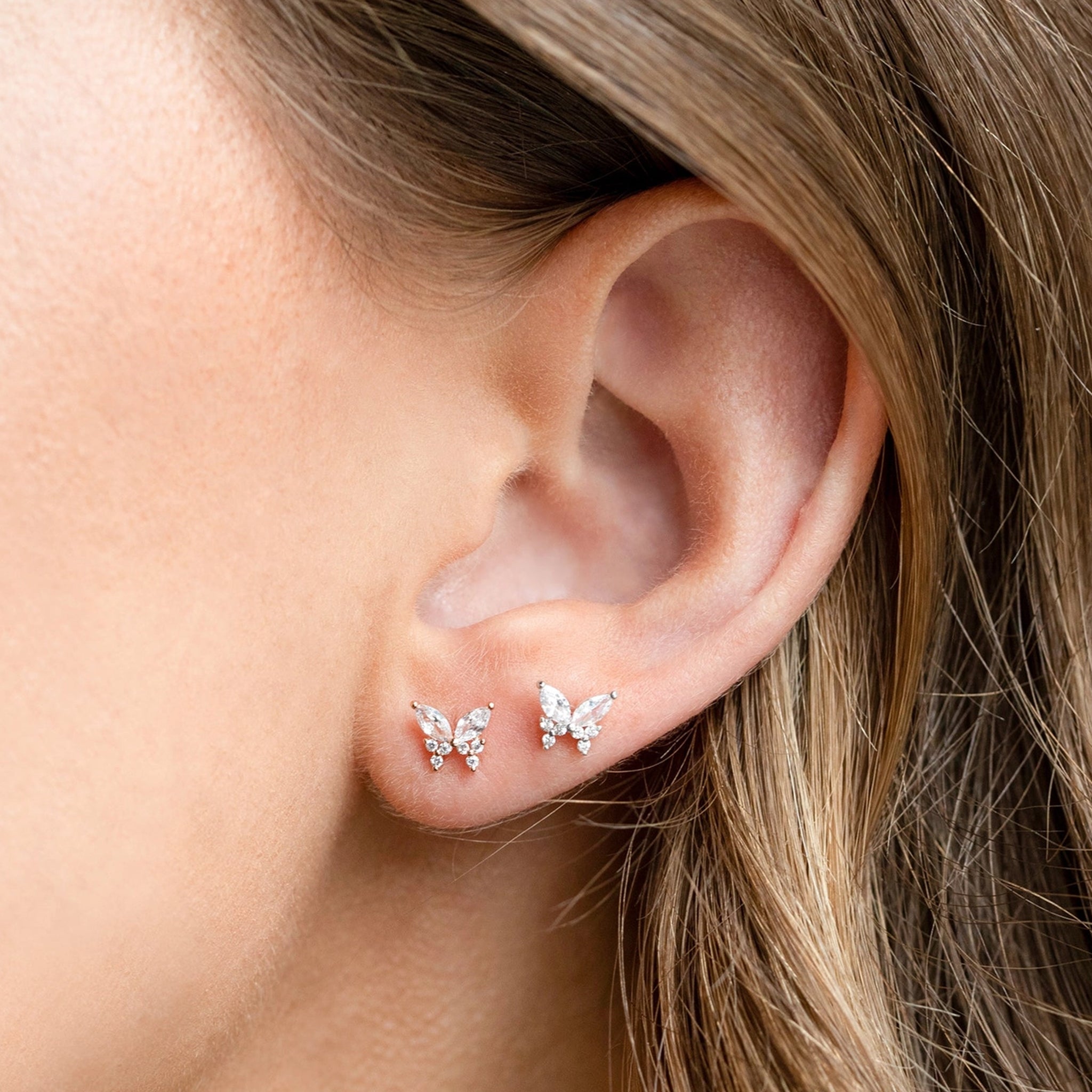 A pair of butterfly shaped stud earrings made out of different shaped cz stones. 