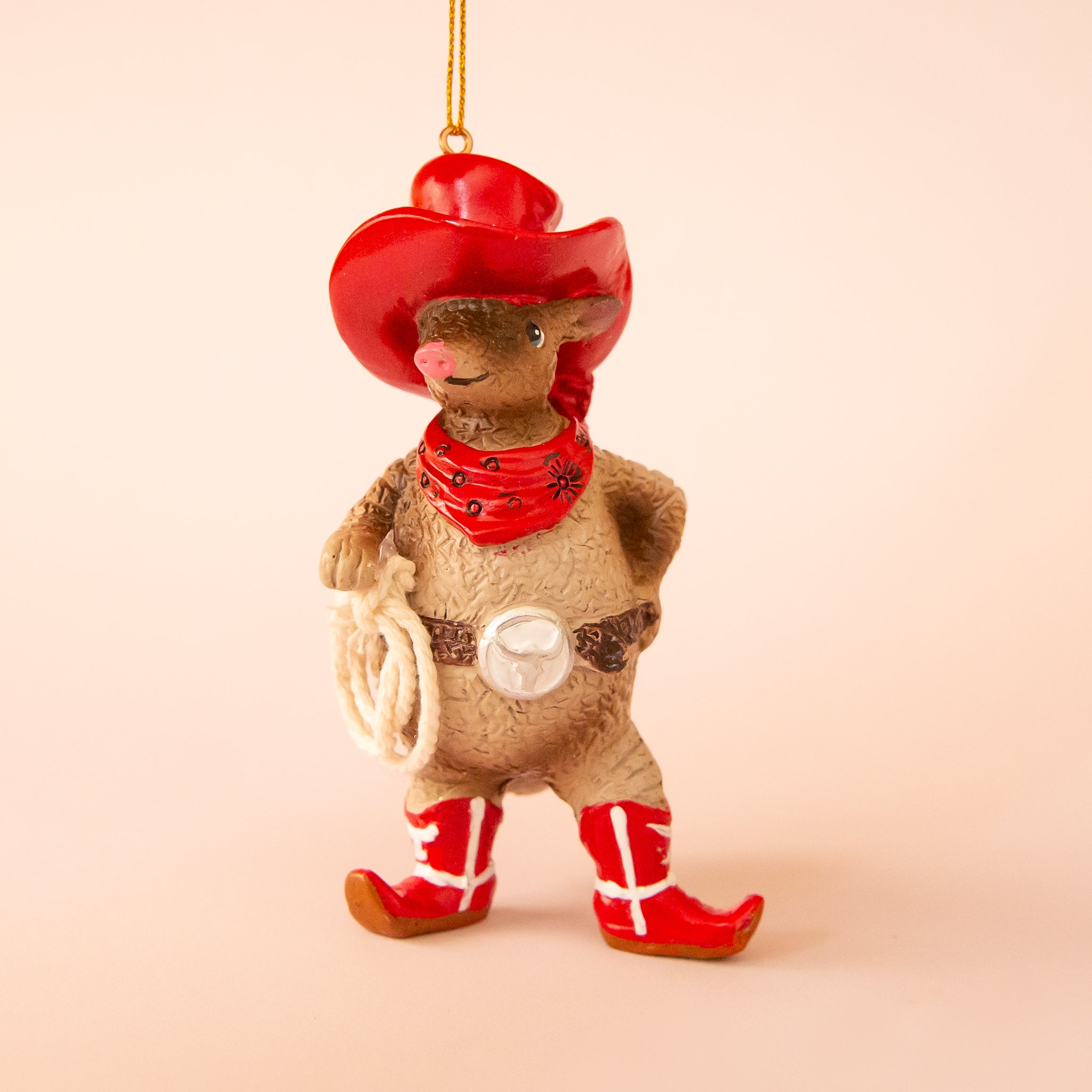 A brown resin armadillo shaped ornament dressed in a red western outfit. 