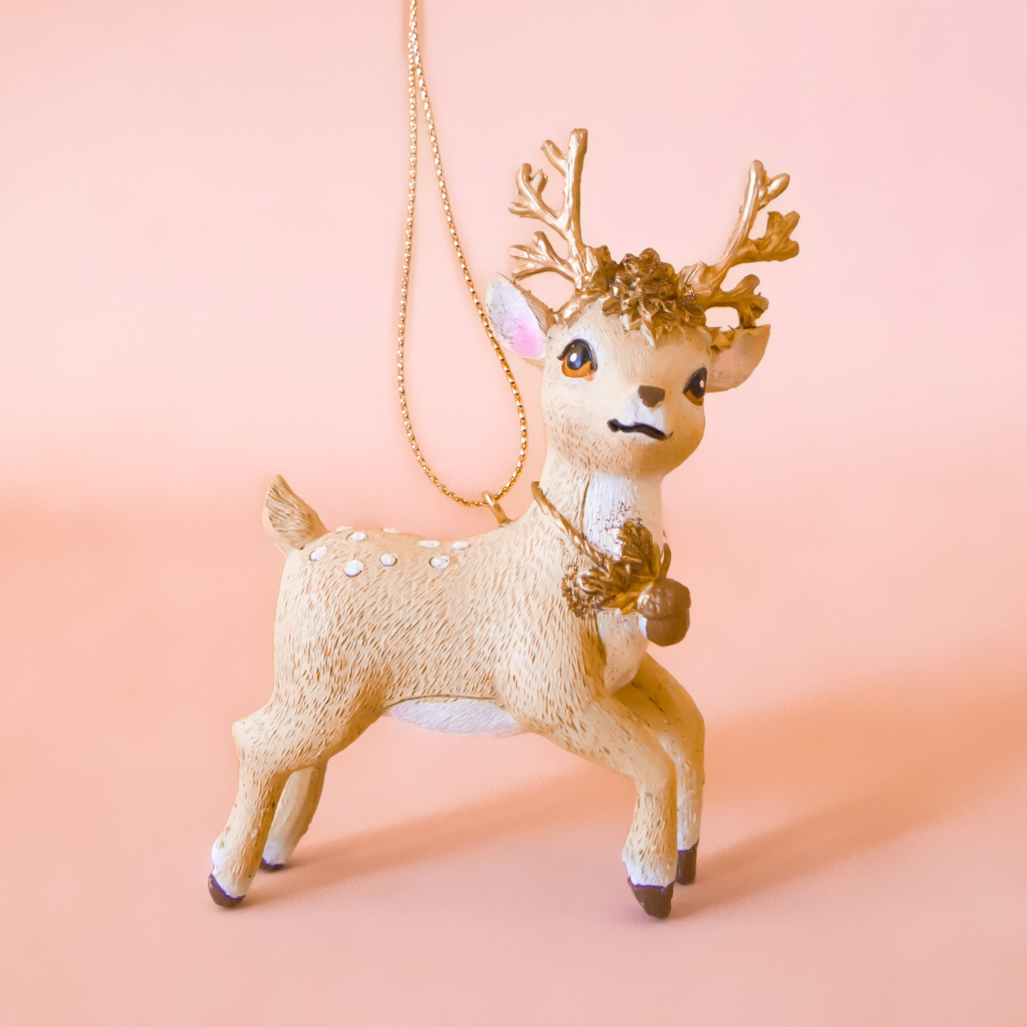 A reindeer shaped ornament in a beige color. 