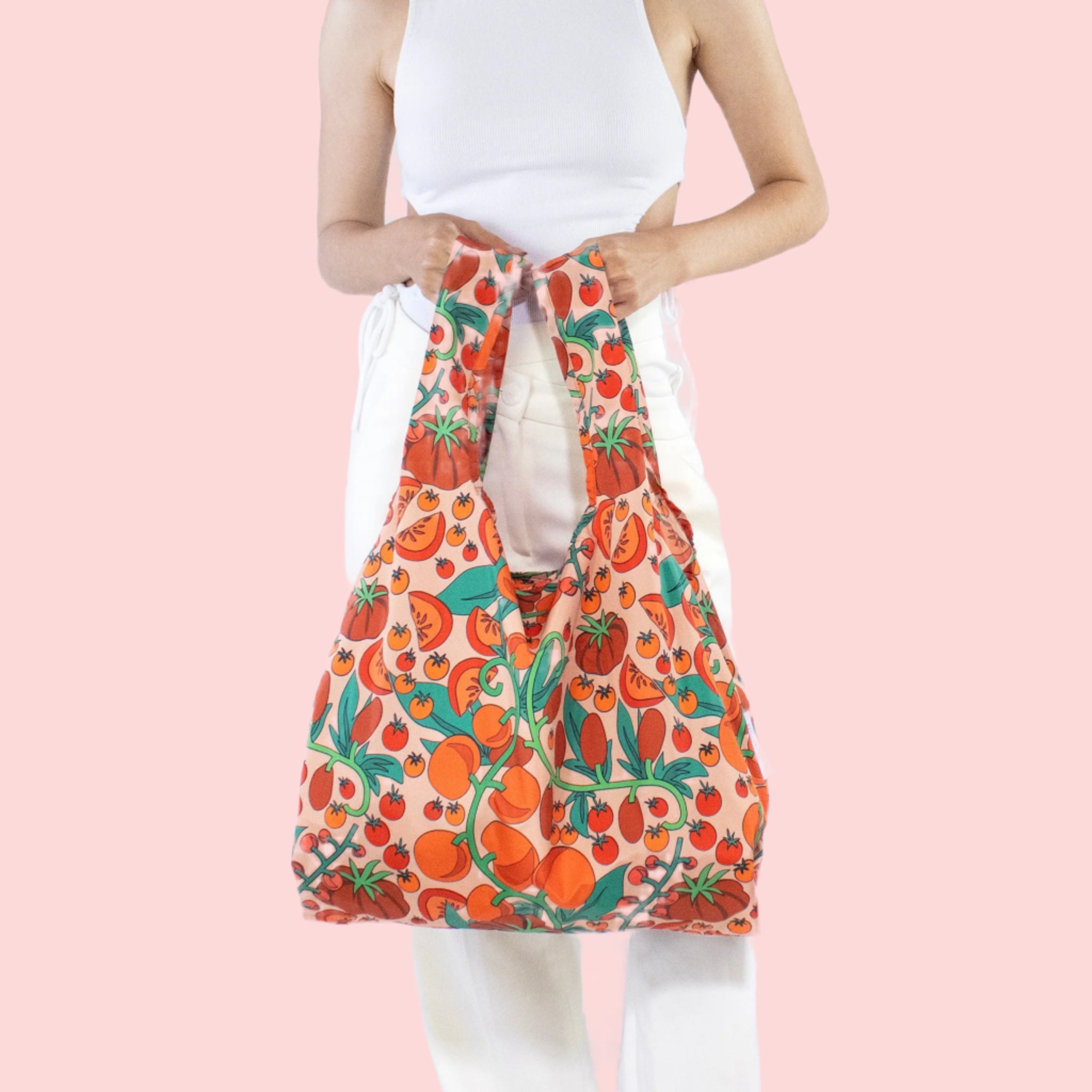 A nylon reusable bag with a red tomato print. 