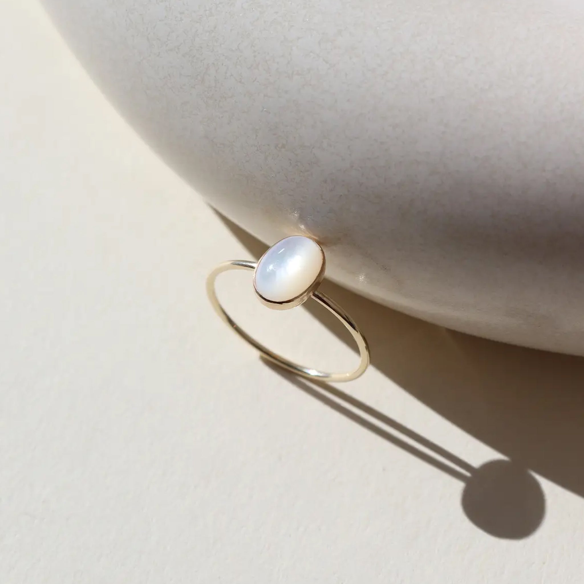 A ring with a round mother of pearl stone.