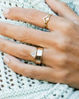 A gold ring with a triangle CZ stone in the center.