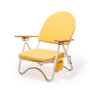 A yellow arched back folding beach chair with wood armrests and white legs. The backside features a zip pocket for storing beachside essentials.