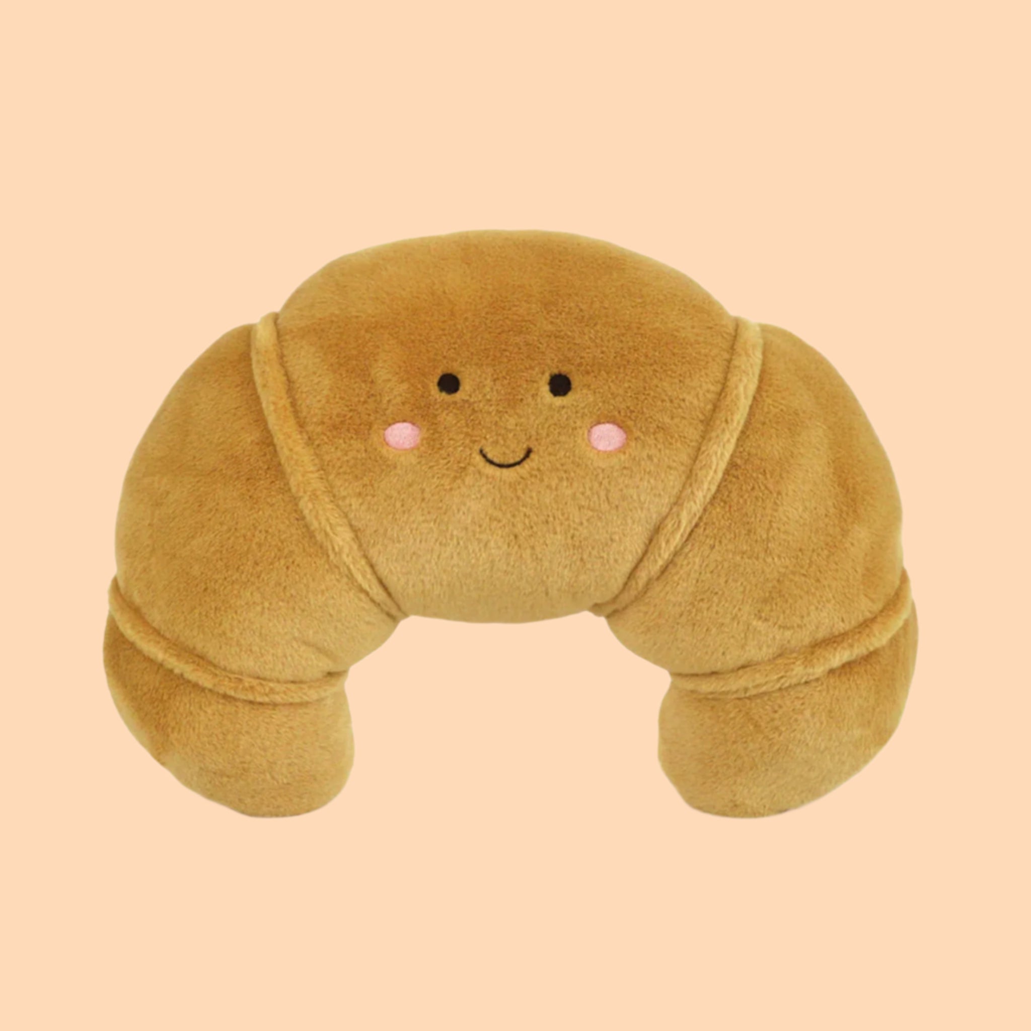 A large croissant shaped stuffed toy with a smiley face. 