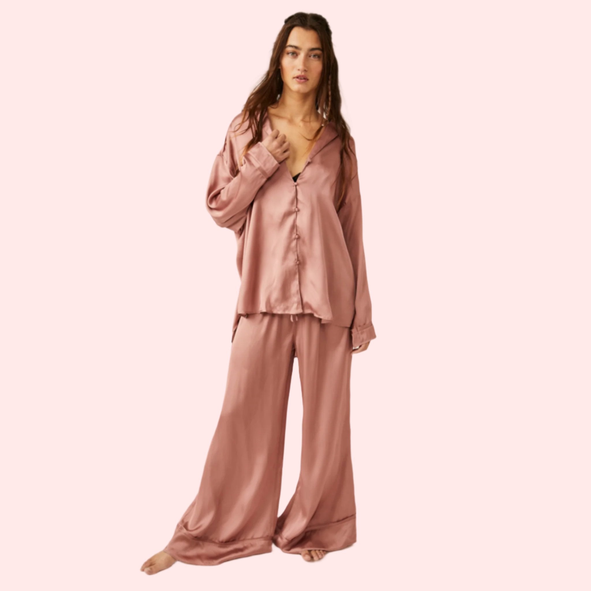 A model wearing an oversized slouchy fit pajama set in a rose gold color. 