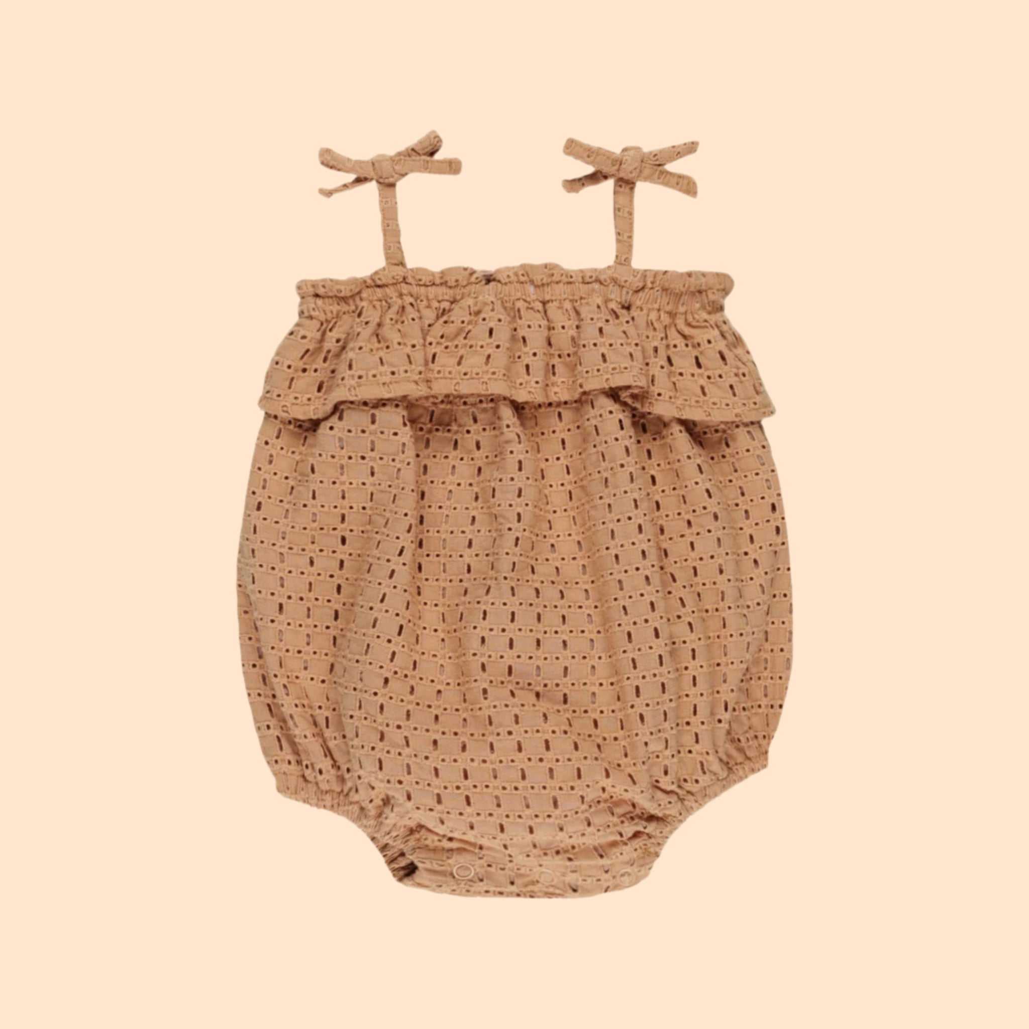 A ruffle eyelet textured bubble romper for babies with strap bow details. 