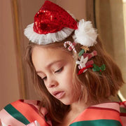 A child model wearing the small Santa hat sequin headband. 