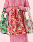 A set of three standard Baggu tote bags with three different Hello Kitty prints on them.