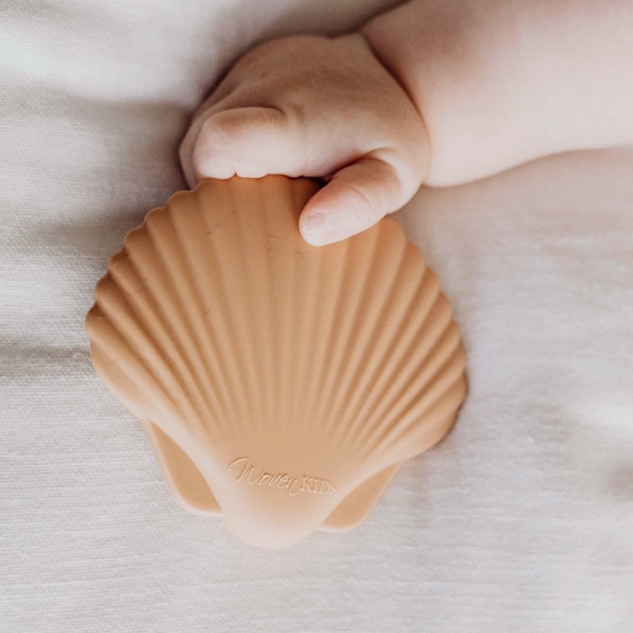 A silicone teether in the shape of a seashell. 