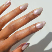 A shimmer nail polish with a holographic, pinkish silver hue. 