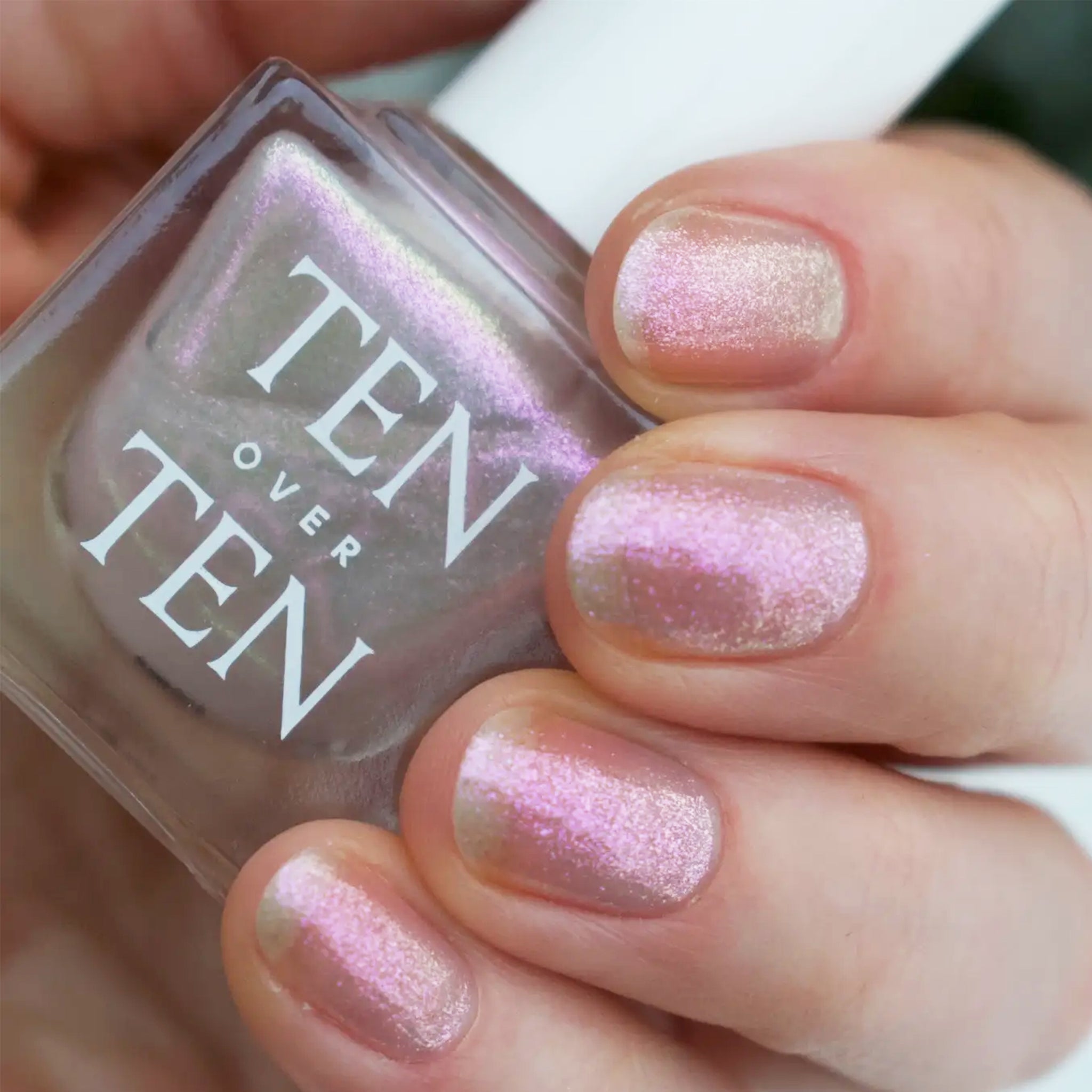 A shimmer nail polish with a holographic, pinkish silver hue.