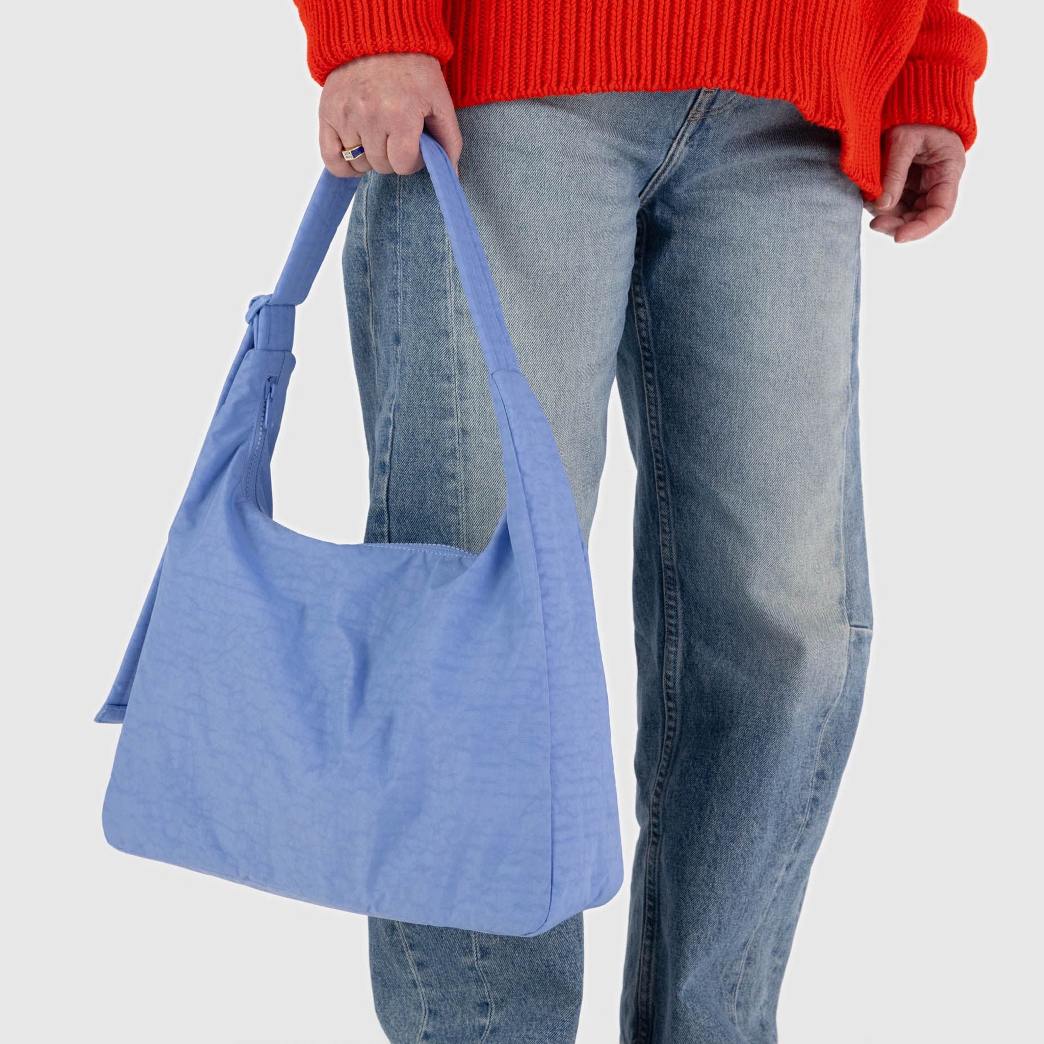 A blue nylon shoulder bag with an adjustable strap.