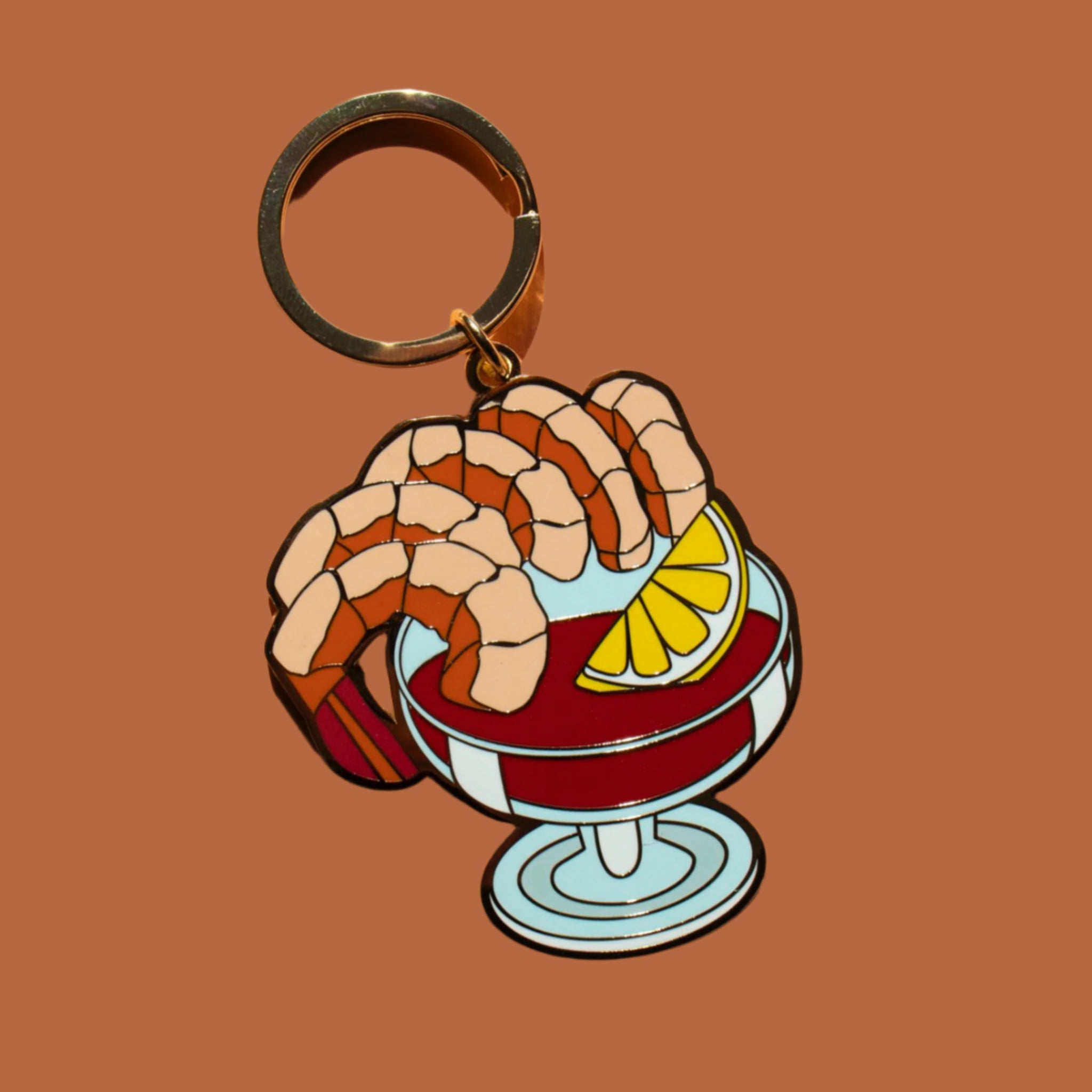 An enamel keychain in the shape of a shrimp cocktail. 