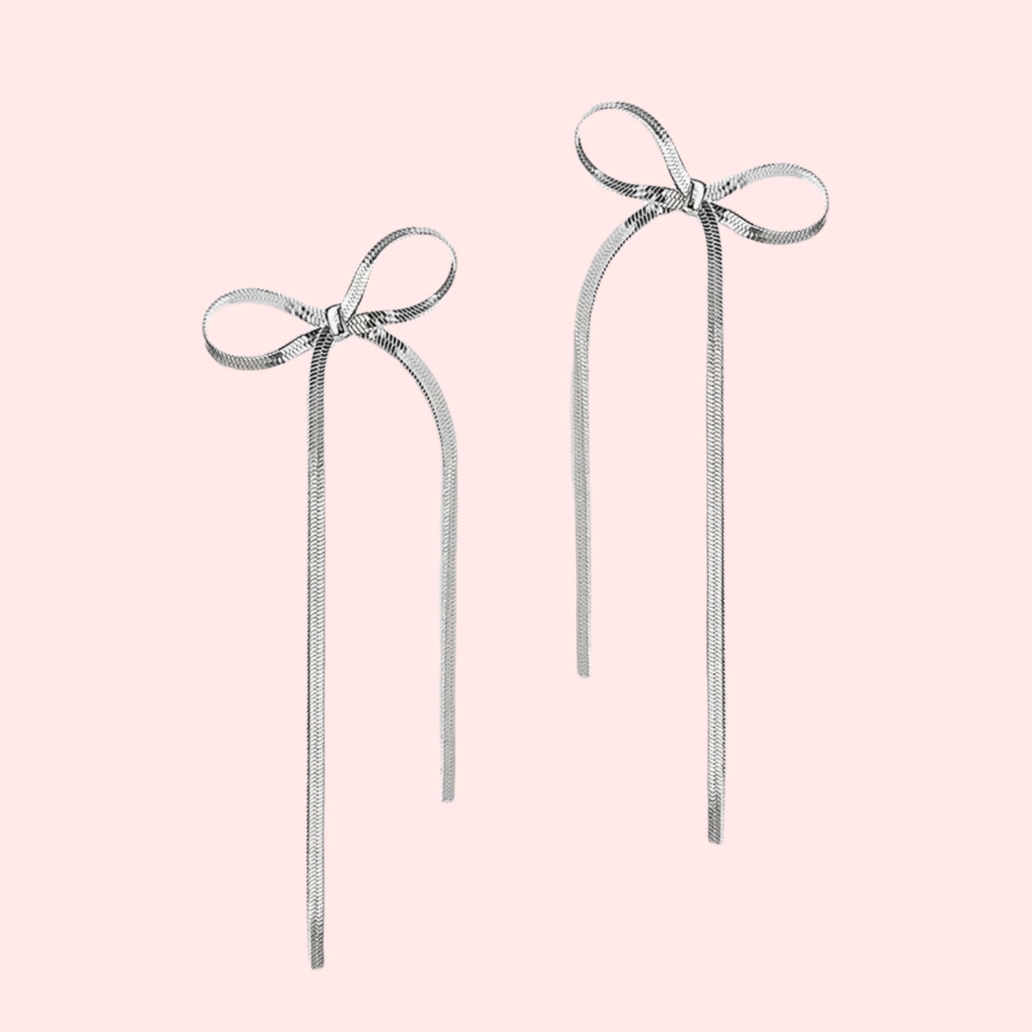 A silver pair of bow shaped earrings. 