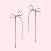 A silver pair of bow shaped earrings. 