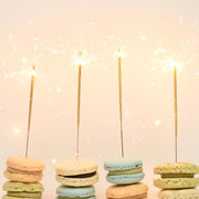 Four of the single sparklers lit on top of stacked macaroons. 