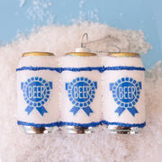 On a blue background is a glass ornament in the shape of a six pack of beers with blue labels.