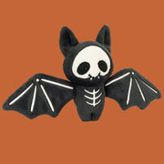 A black bat shaped skeleton stuffed toy.