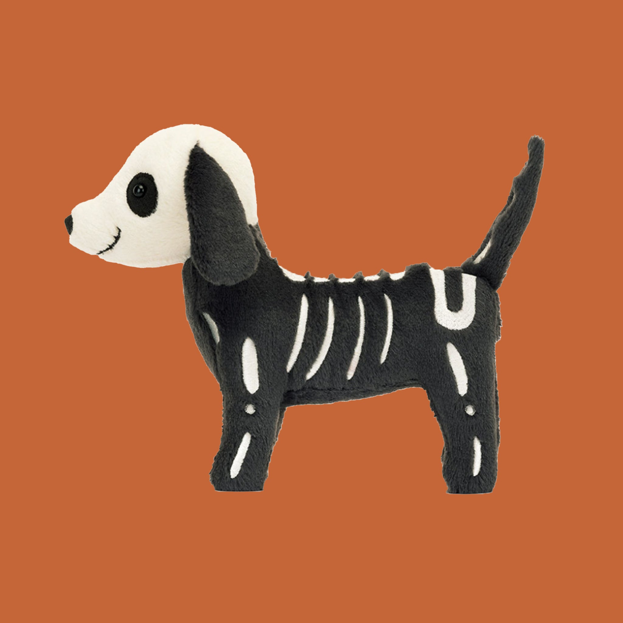 A black and white skeledog shaped stuffed toy.