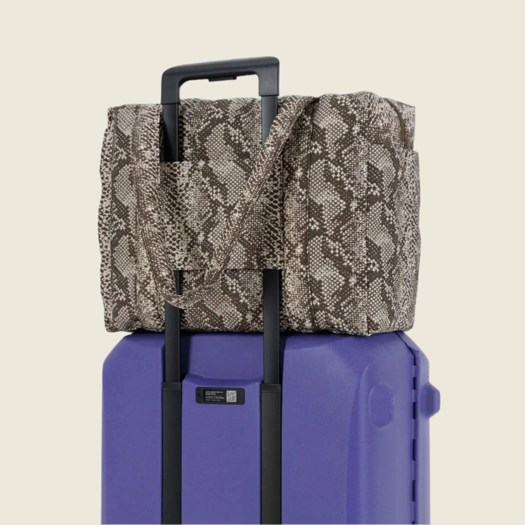 A snakeskin printed nylon cloud carry on. 