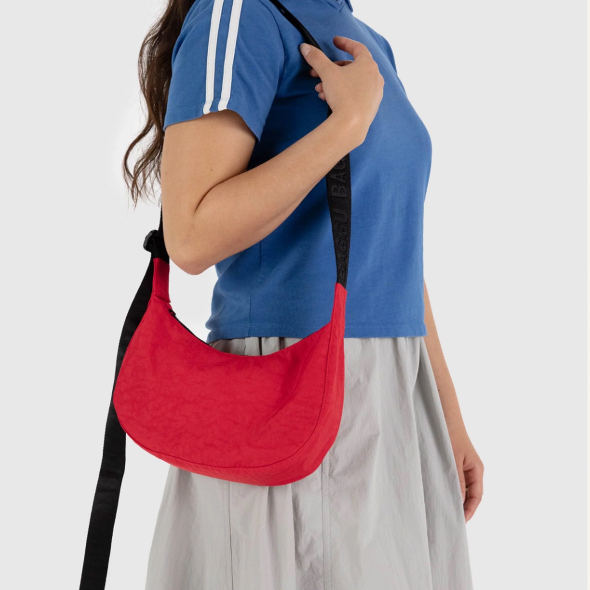 A small red nylon handbag with a back adjustable strap.