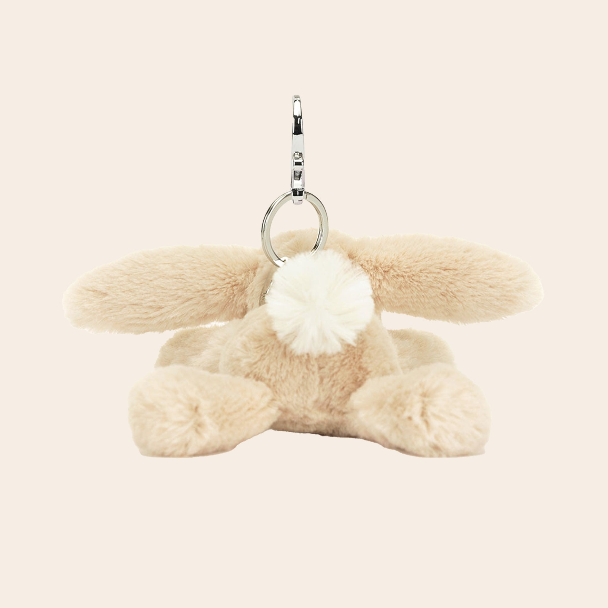 A mini bunny stuffed animal on a silver keychain.