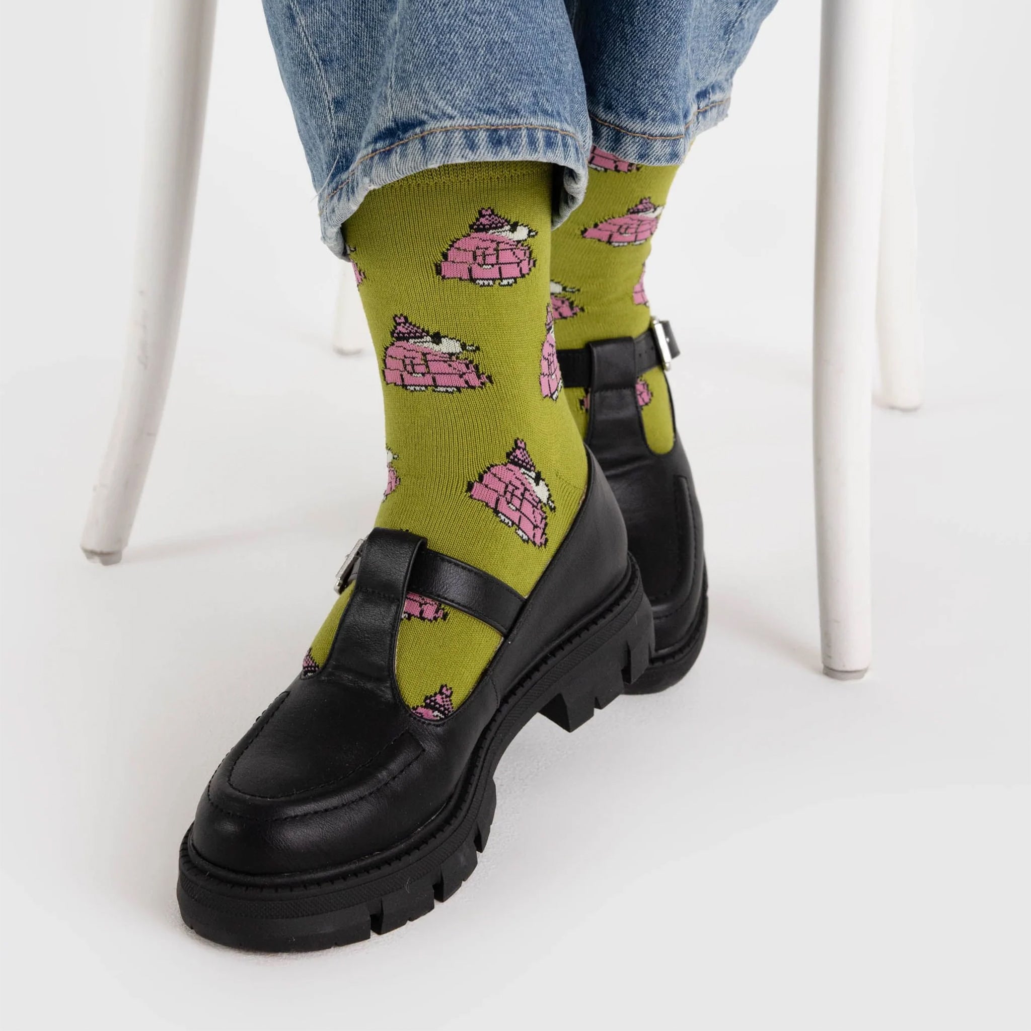 A pair of chartreuse green and pink crew socks with a Snoopy puffer jacket print. 