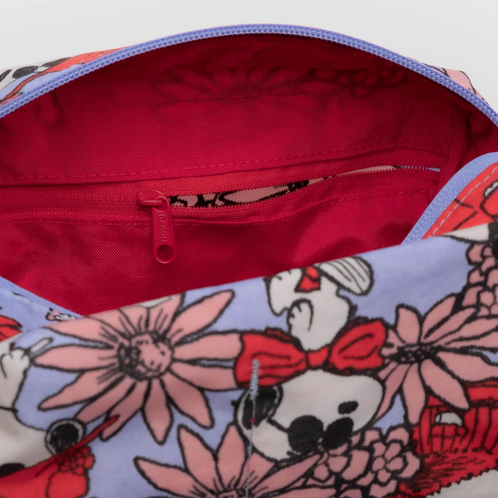 A blue dopp kit with a red and pink floral snoopy print.