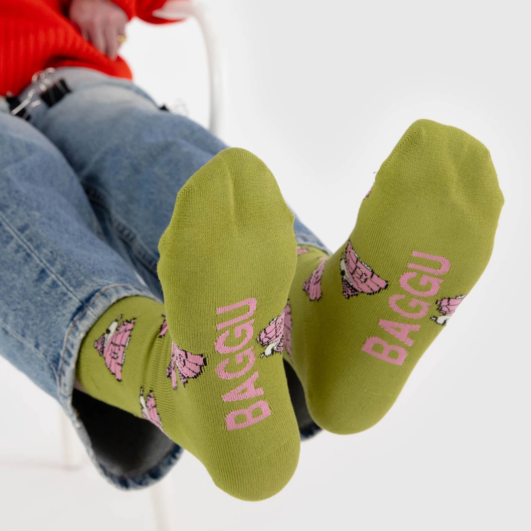 A pair of chartreuse green and pink crew socks with a Snoopy puffer jacket print. 