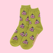 A pair of chartreuse green and pink crew socks with a Snoopy puffer jacket print. 