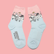 A pair of blue and pink crew socks with a graphic of snoopy and a snowman. 