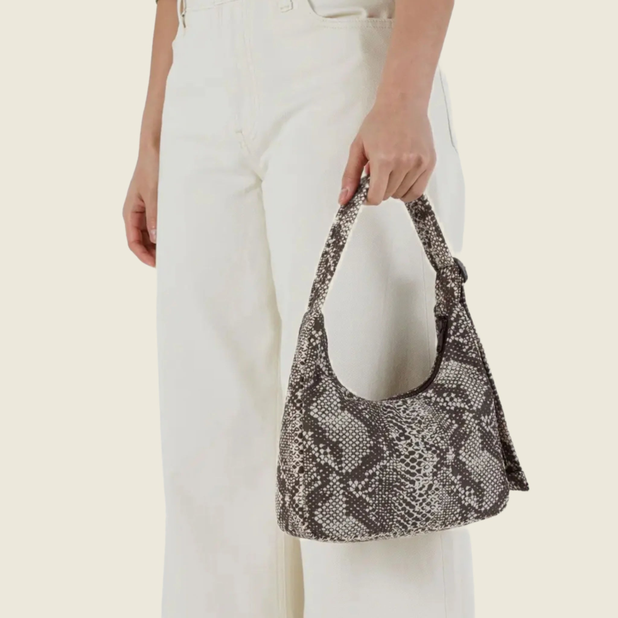 A nylon mini shoulder bag with an adjustable strap and a snakeskin print. 