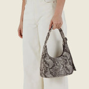 A nylon mini shoulder bag with an adjustable strap and a snakeskin print. 