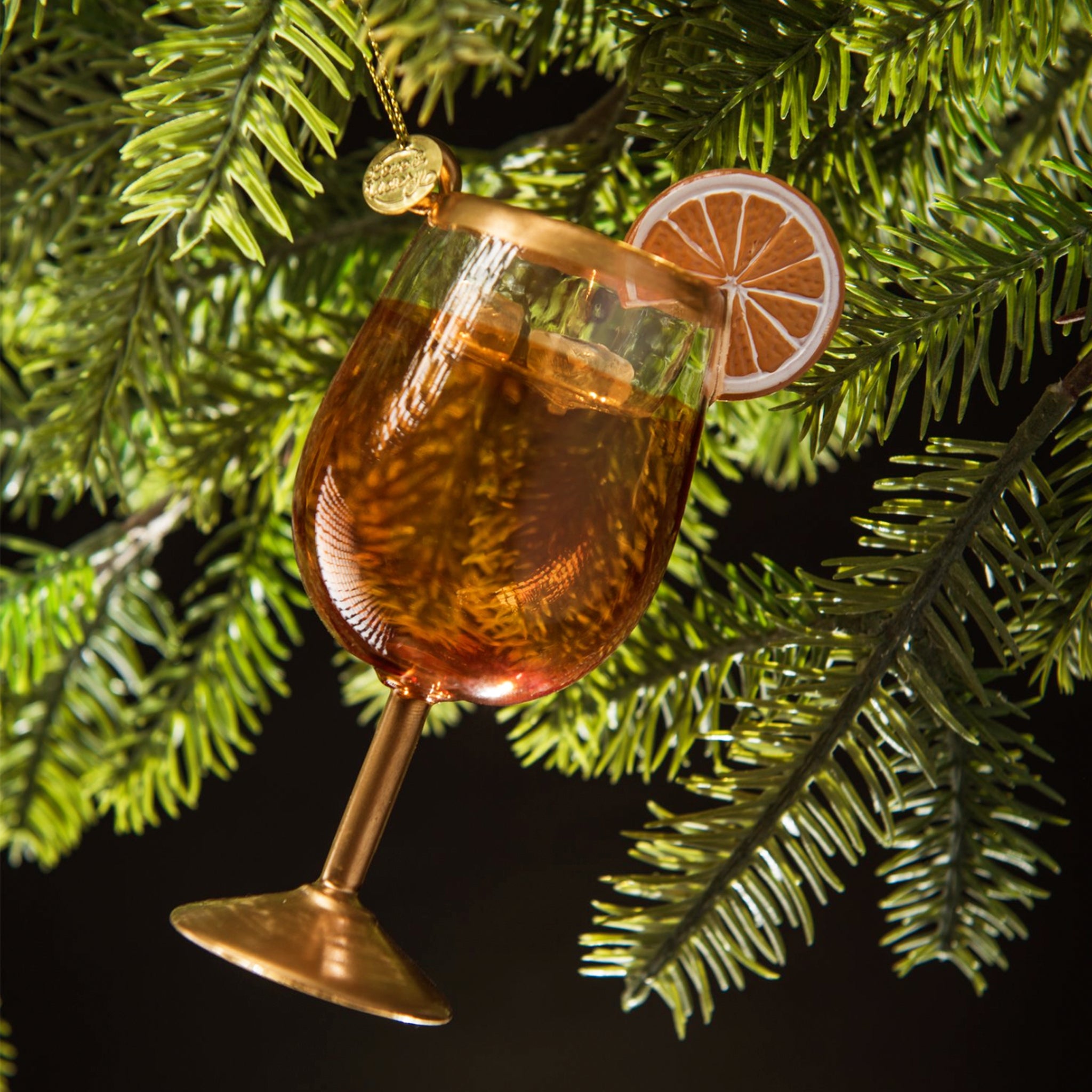 An orange and gold glass aperol spritz cocktail shaped ornament. 