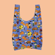 A purple reusable nylon bag with a charlie brown pumpkin patch pattern all over. 