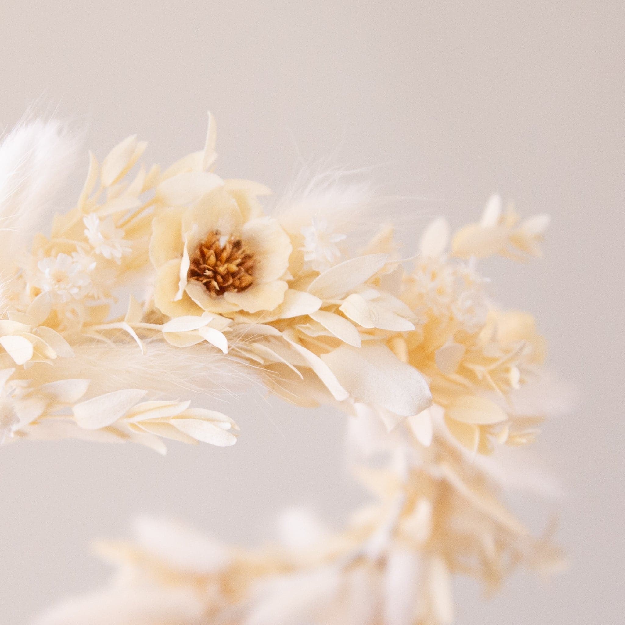 A flower crown made up of neutral dried florals and a tie detail at the back. 