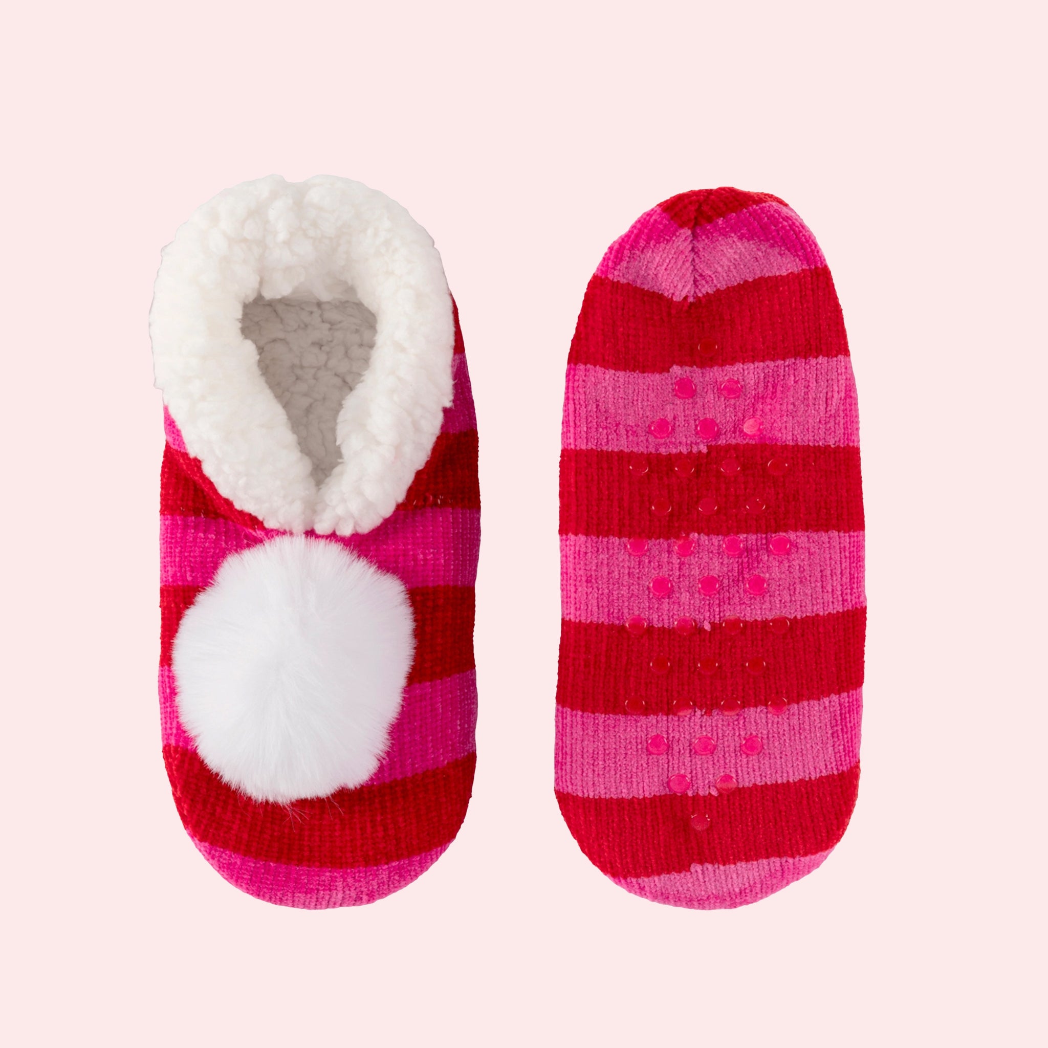 A pink and red slipper sock with rubber grips at the bottom and a white pom on top. 