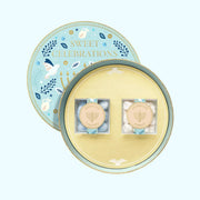 A circle container filled with two boxes of Kosher candies in two acrylic boxes and decorated with Hanukkah themed images and designs. 