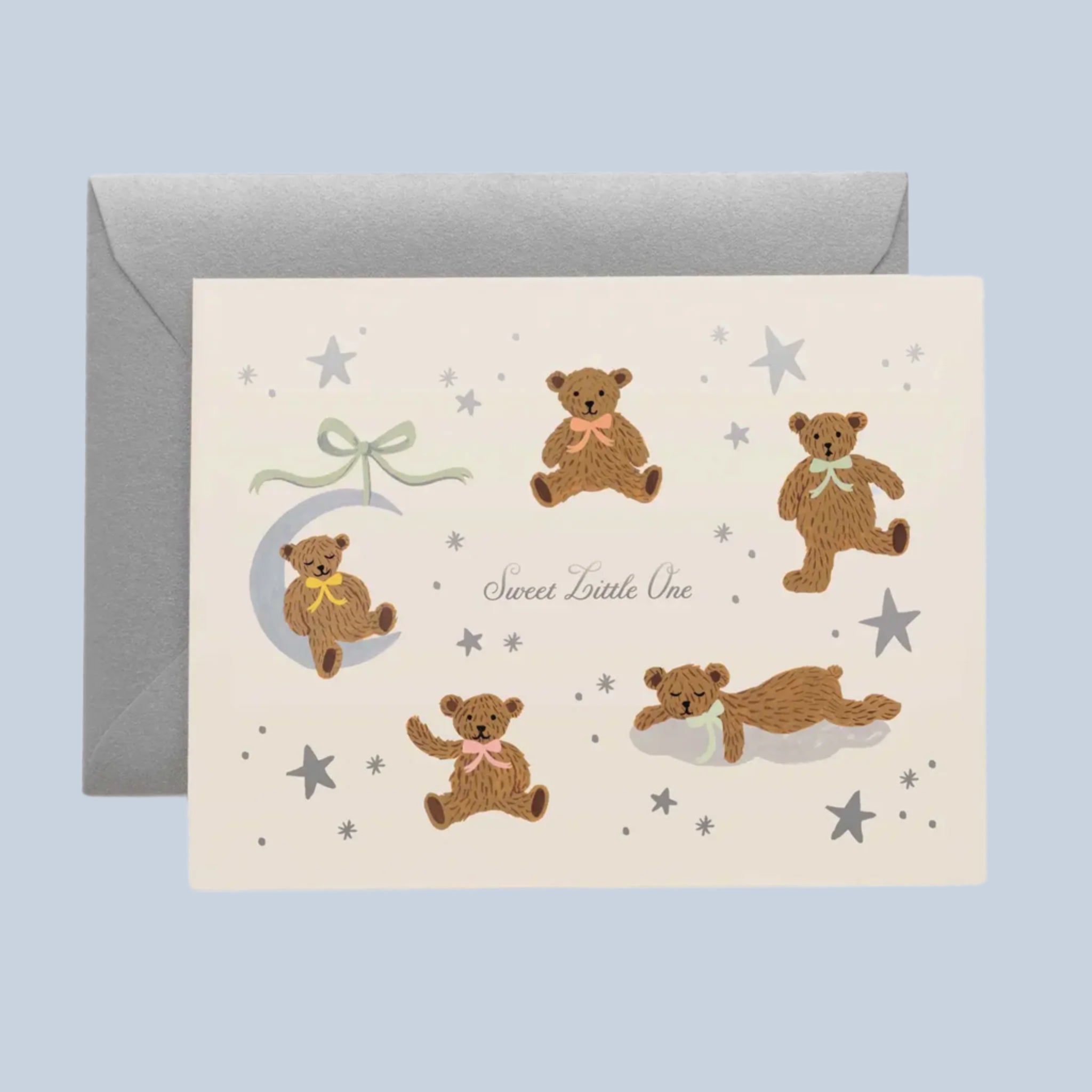 A white card with a teddy bear print with moon and star details and text in the center that reads, &#39;Sweet Little One&#39;. 