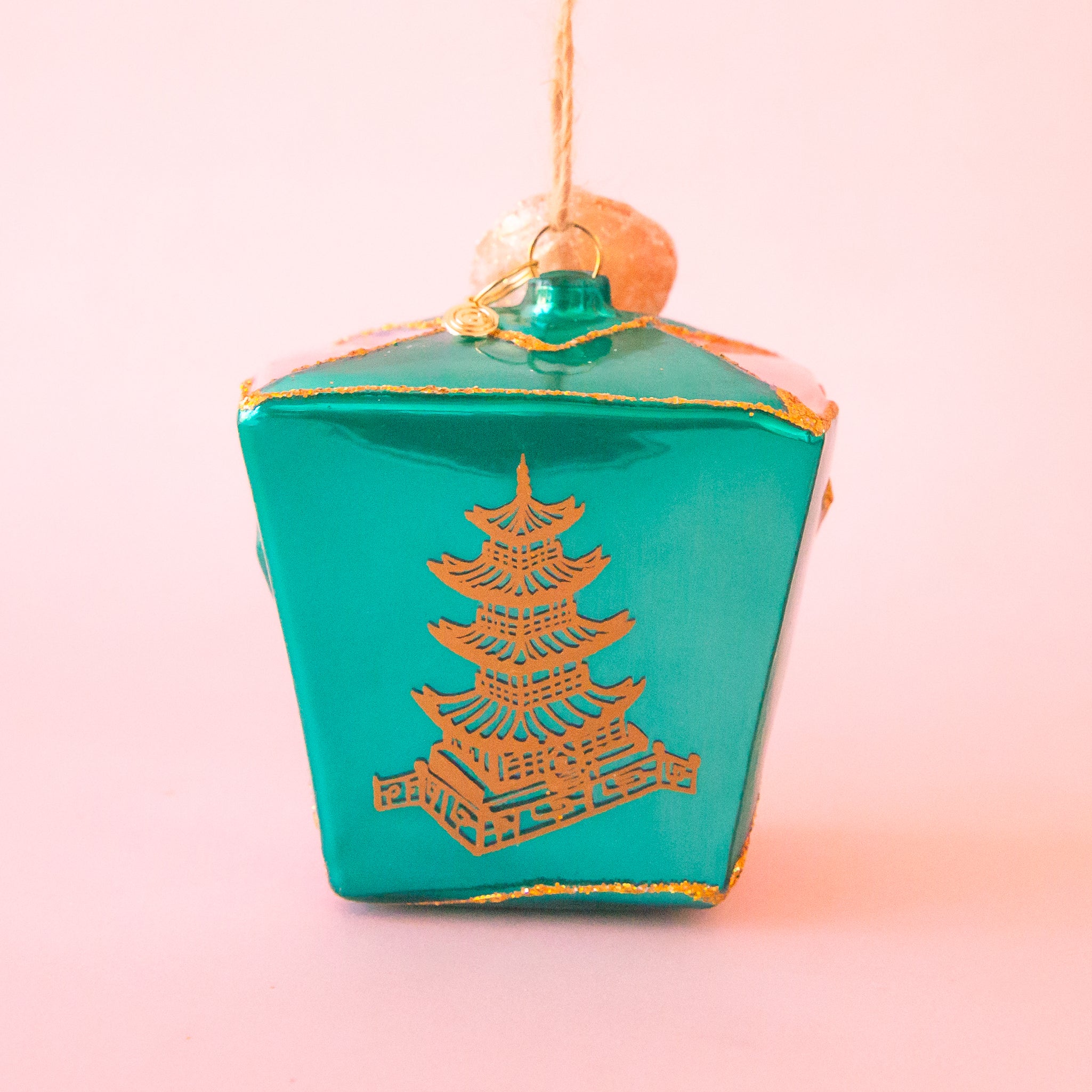 A blue glass ornament in the shape of takeout box. 