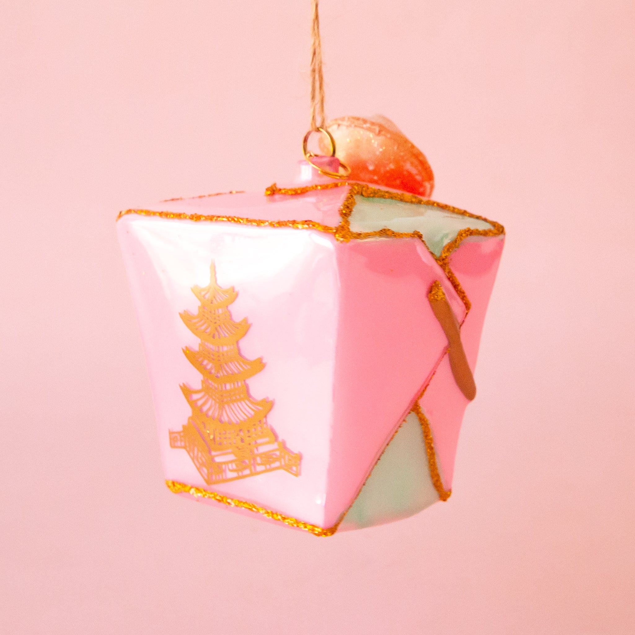 A pink glass take out box shaped ornament. 