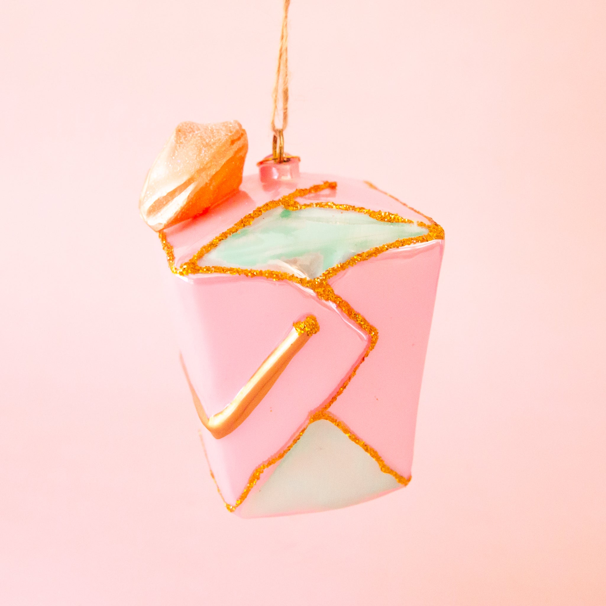 A pink glass take out box shaped ornament. 