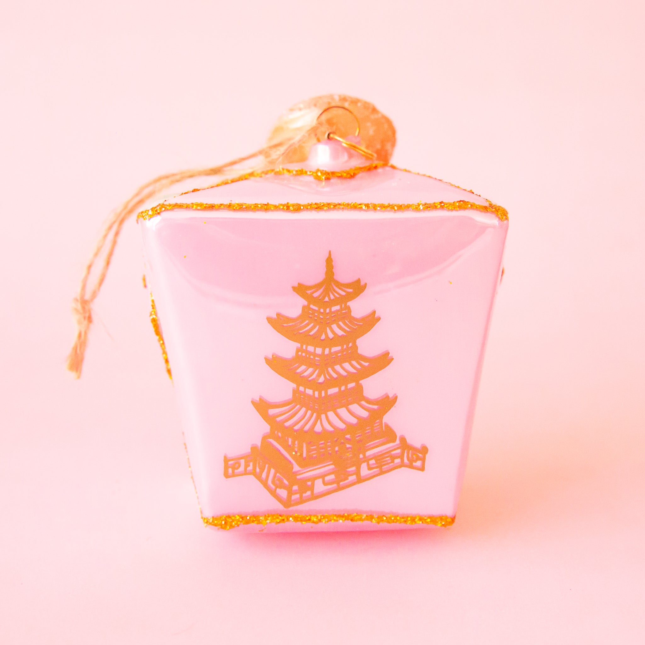 A pink glass take out box shaped ornament. 