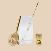 A gold bar set with a ribbed glass mixer. 