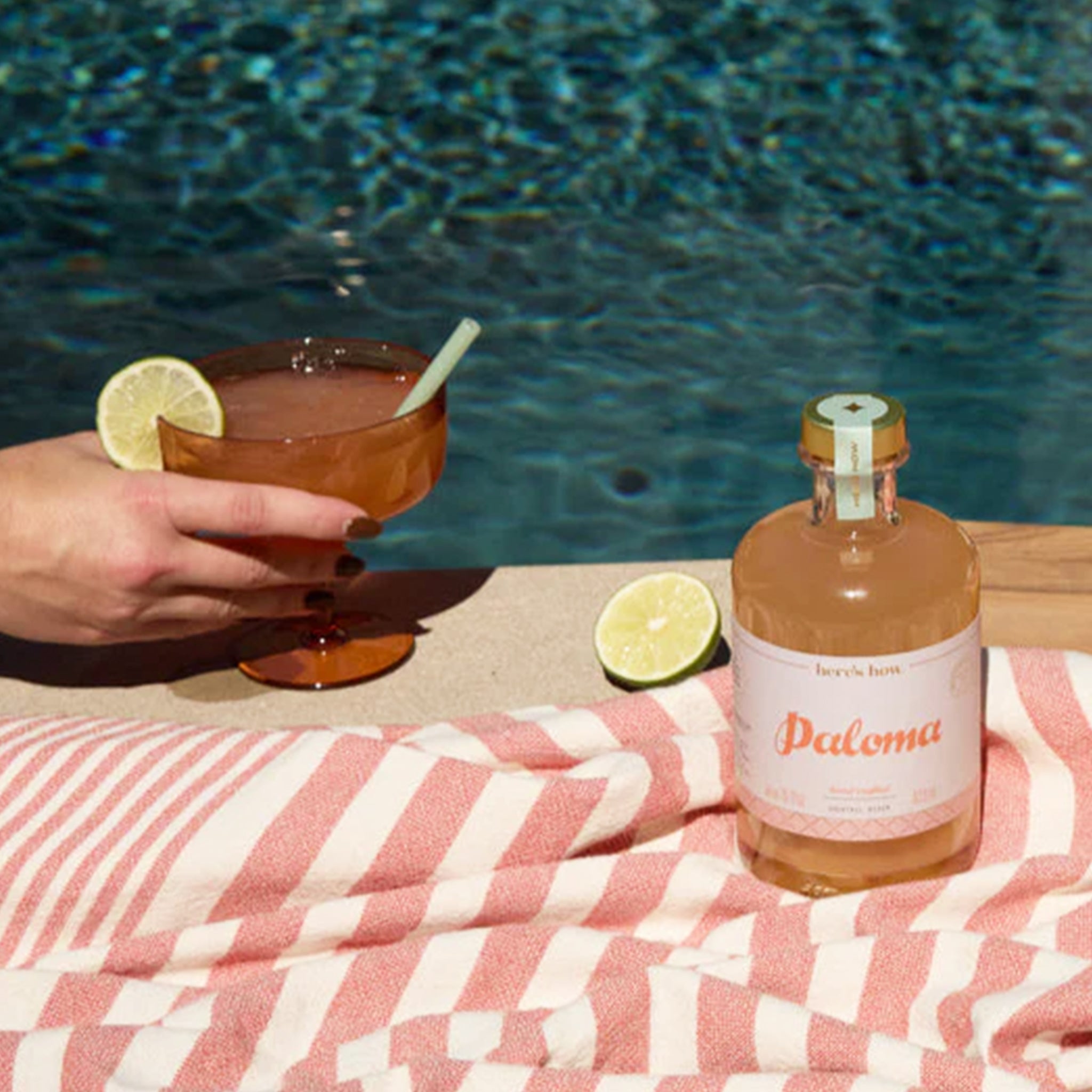 A photo of a poolside image with a cocktail mix and a margarita glass. 